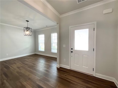 Entrance foyer featuring visible vents, dark wood-