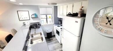Kitchen with white appliances, a sink, white cabin