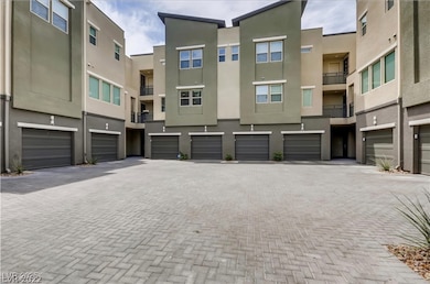 View of property featuring a garage and driveway