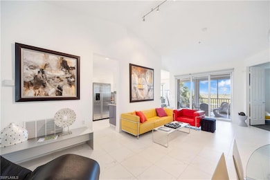 Living room with track lighting, baseboards, and high vaulted ceiling