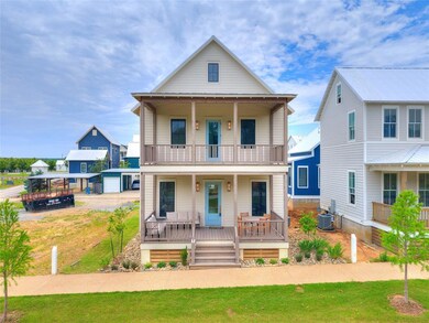 View of front of house with a balcony, a porch, central AC, an outbuilding, and a front yard