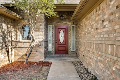 Property entrance with brick siding and a shingled roof