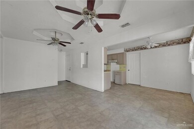 Unfurnished living room featuring ceiling fan and light tile floors