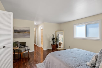 Bedroom with wood finished floors and baseboards