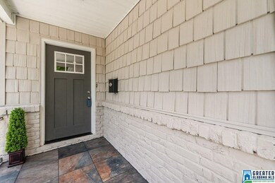 Front entry with stone porch and shake siding.