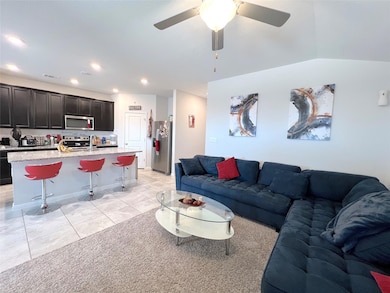 Living room featuring ceiling fan, light tile pat