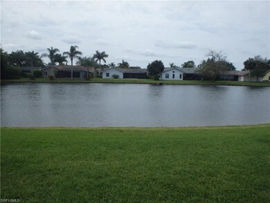 Lake view with wide grassy area behind the home.