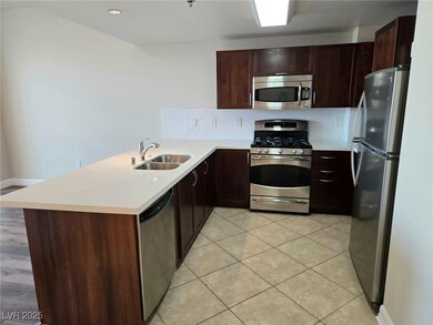 Kitchen with light tile patterned floors, a sink,