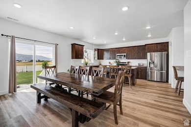 Dining area with light wood-style floors, recessed lighting, and a mountain view