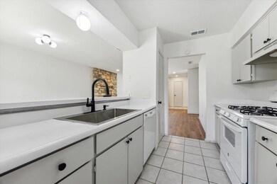 Kitchen with white appliances, ventilation hood, 