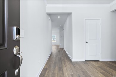 Hall with hardwood / wood-style flooring and crown