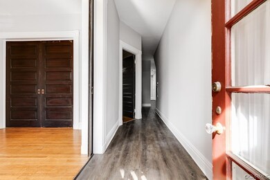 Corridor with hardwood / wood-style floors
