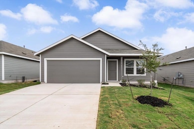 Ranch-style house with driveway, a front lawn, and a garage