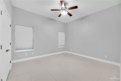 Spare room featuring ceiling fan and light tile floors