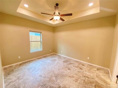 Empty room featuring recessed lighting, ceiling fan, baseboards, and a tray ceiling