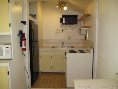 Kitchenette with refrigerator, stove, and sink.