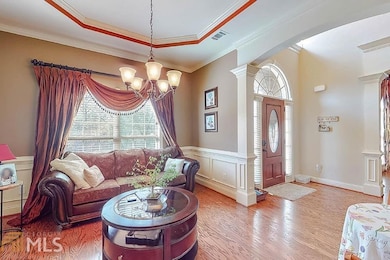 Living room with wood finished floors, visible ven