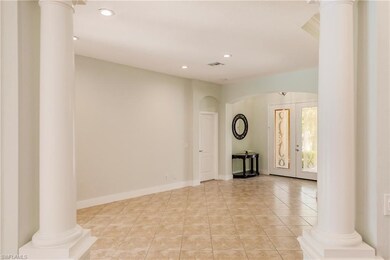 Living room with pillar columns and arched opening
