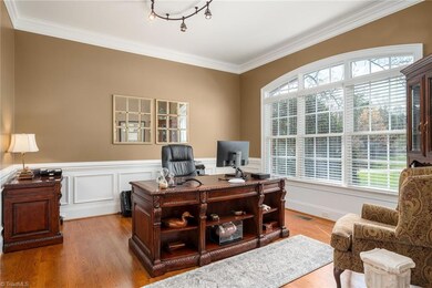 Generous main level Office has triple window with arched transoms, picture frame wainscoting & chair rail