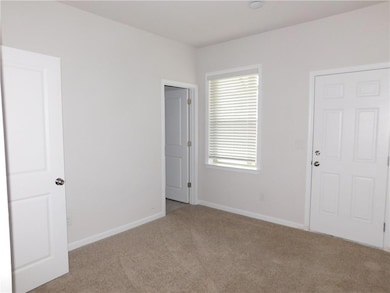 Unfurnished room with baseboards and light colored carpet