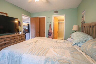 Bedroom featuring ensuite bath, visible vents, and