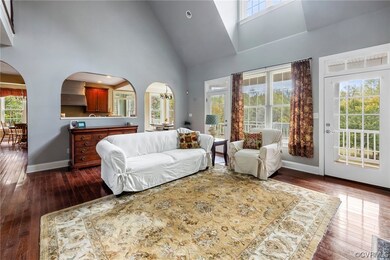 Living room featuring high vaulted ceiling and dar