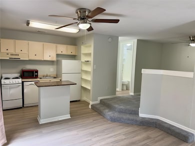 Kitchen featuring white appliances, ceiling fan, 