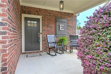 Entrance to property with covered porch and brick 