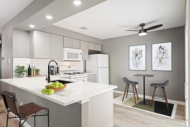 Kitchen featuring white appliances, a sink, backs