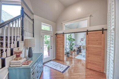 Foyer featuring high vaulted ceiling, light wood-t