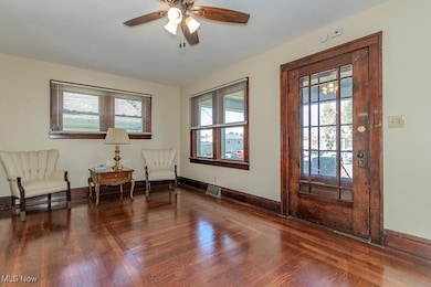 Sitting room featuring healthy amount of natural light, dark wood-type flooring, and ceiling fan