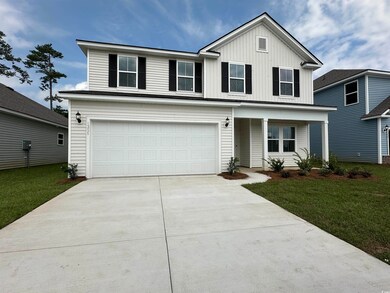 Front facade featuring a front yard and a garage