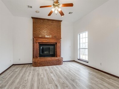 Unfurnished living room featuring a brick fireplac