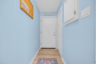 Doorway to outside featuring baseboards, light woo