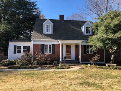 Cape cod-style house featuring a front yard