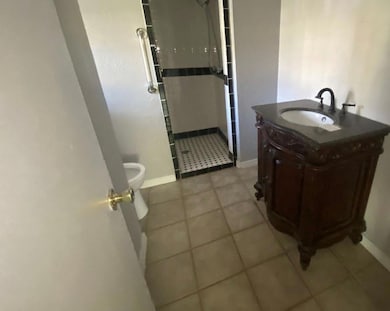 Bathroom with vanity, tile floors, and toilet