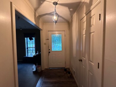 Entryway featuring a textured ceiling, crown moldi