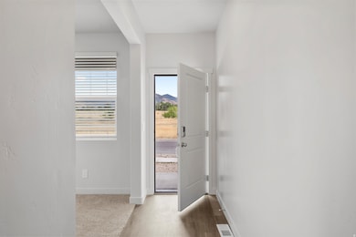 Doorway featuring baseboards and wood finished floors