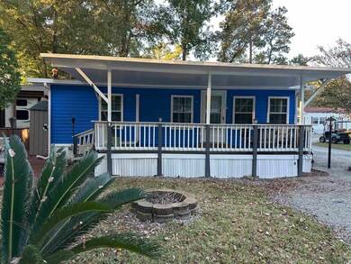 Back of property featuring an outdoor fire pit and a porch