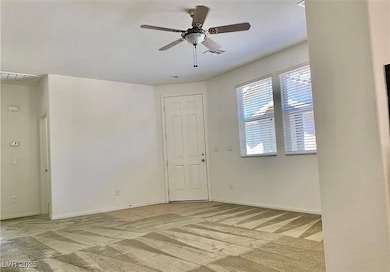 Empty room featuring light carpet, ceiling fan, an