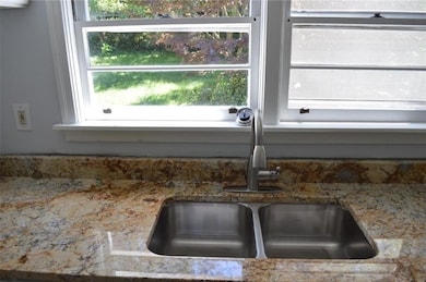 Kitchen view of a sink and light stone countertops