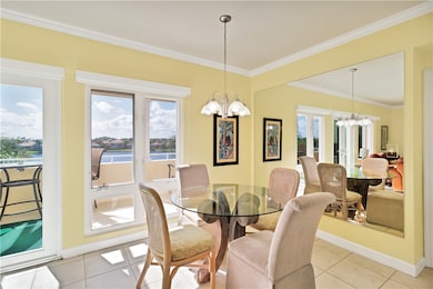 Dining room featuring a chandelier, crown molding, tile patterned floors, a water view, and french doors