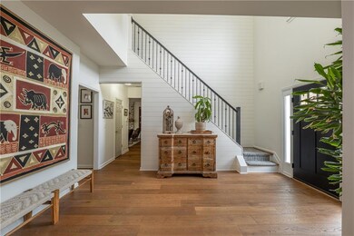 Two story entryway featuring stairs and hardwood floors.