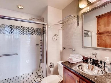 Bathroom featuring tile walls, vanity, a stall sh