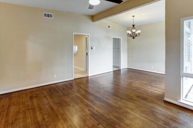 View from the front doorway into the formal living room and formal dining room beyond. These are original wood floors and are still lovely.