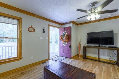 Living room with hardwood flooring, crown molding 