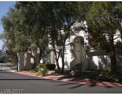View of asphalt street with a gate and a gated ent