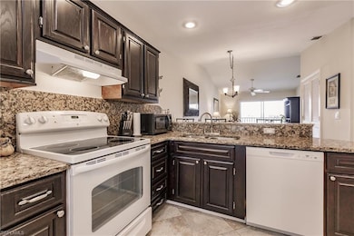 Kitchen featuring vaulted ceiling, light stone cou