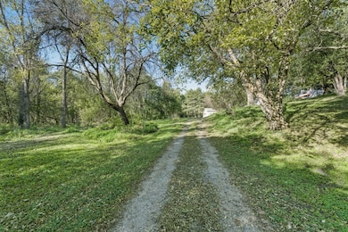 Dwelling is nestled beyond this long winding driveway.