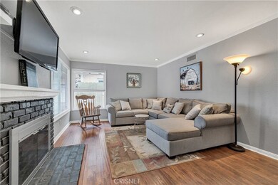 Living Room with Brick Fireplace, Crown Molding & Wood laminate flooring!